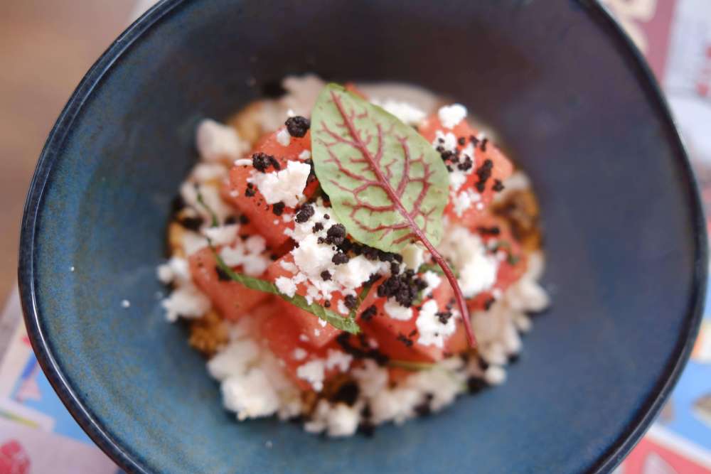 Ensalada de sandía y queso feta con especias de Miami, vinagreta balsámica, aceitunas Kalamata deshidratadas y menta