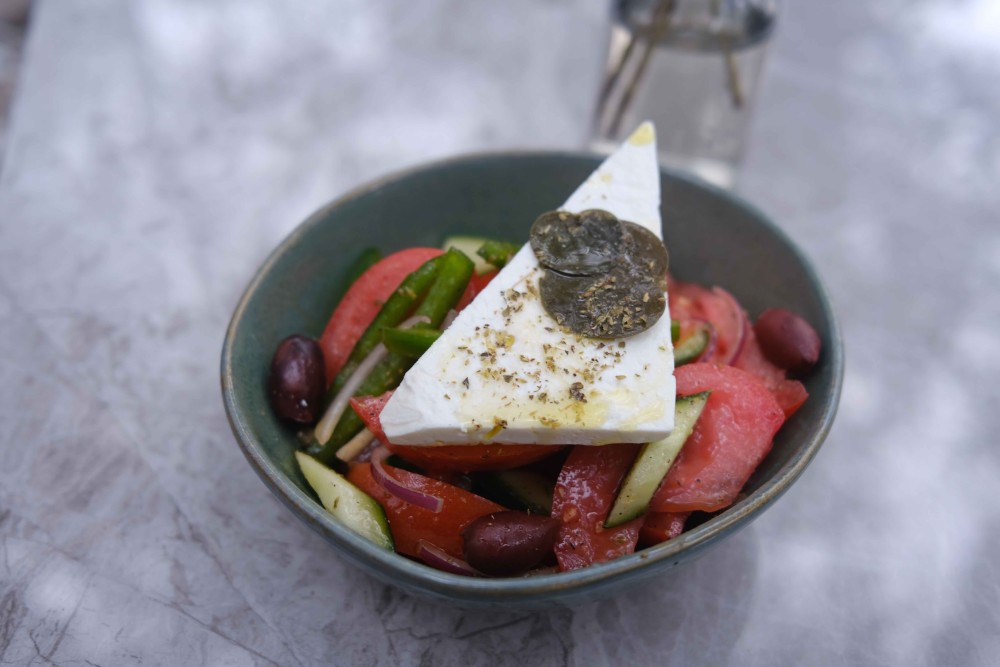 Ensalada griega con tomate, queso feta, cebolla roja, alcaparras, pepinos, aceitunas kalamata y pimiento verde