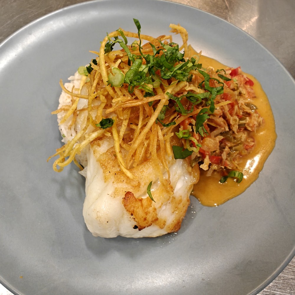 Fresh catch of the day topped with kalamansi sofrito, crispy plantain chips, on a bed of coconut rice.