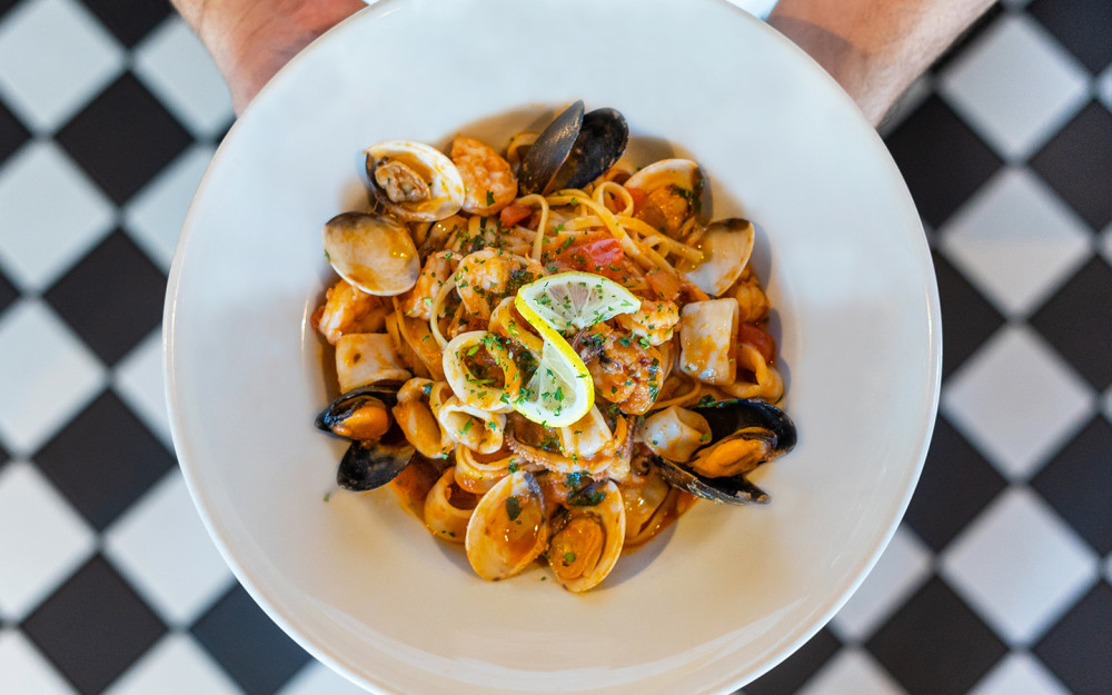 Итальянская классика! Паста лингвини с креветками, мидиями, моллюсками и кальмарами с чесноком, белым вином и базиликом в пикантном соусе помидор.