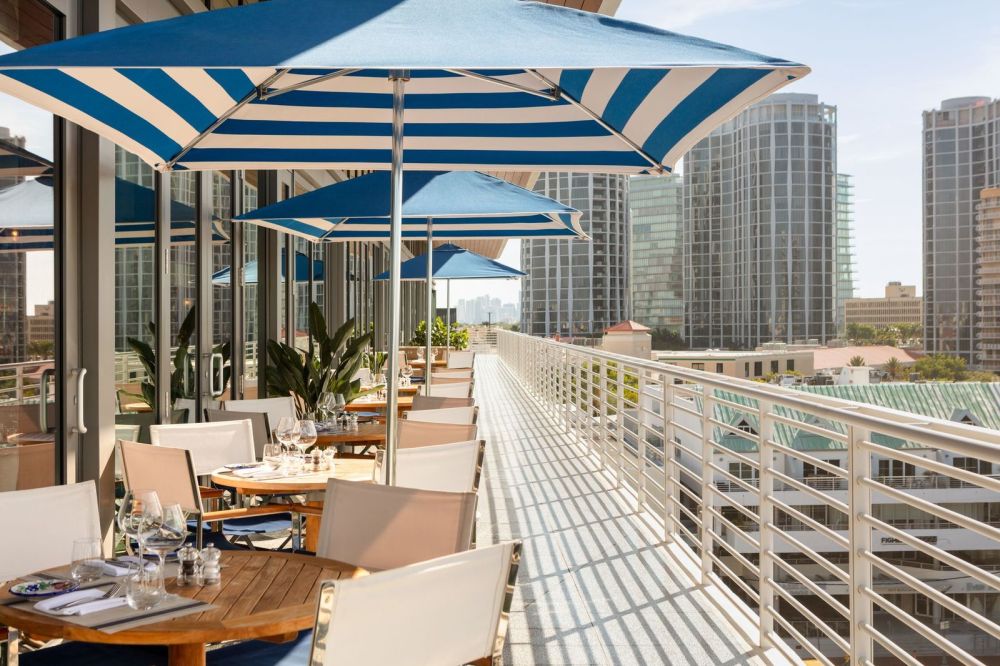 Damos la bienvenida a los huéspedes del hotel a cenar en nuestra terraza cubierta junto a la bahía con vistas panorámicas.