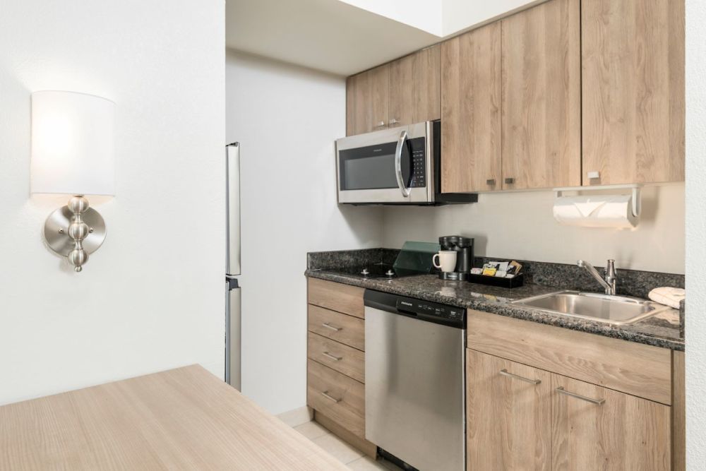 Suite Kitchen - cozinha totalmente equipada com bancadas em granito, geladeira grande, fogão, forno de micro-ondas e cafeteira
