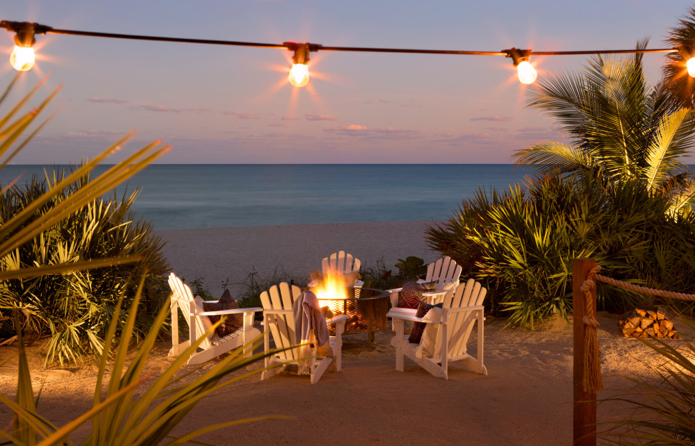 Passez la soirée à vous connecter autour d'un foyer installé dans le sable juste à côté de l'océan.