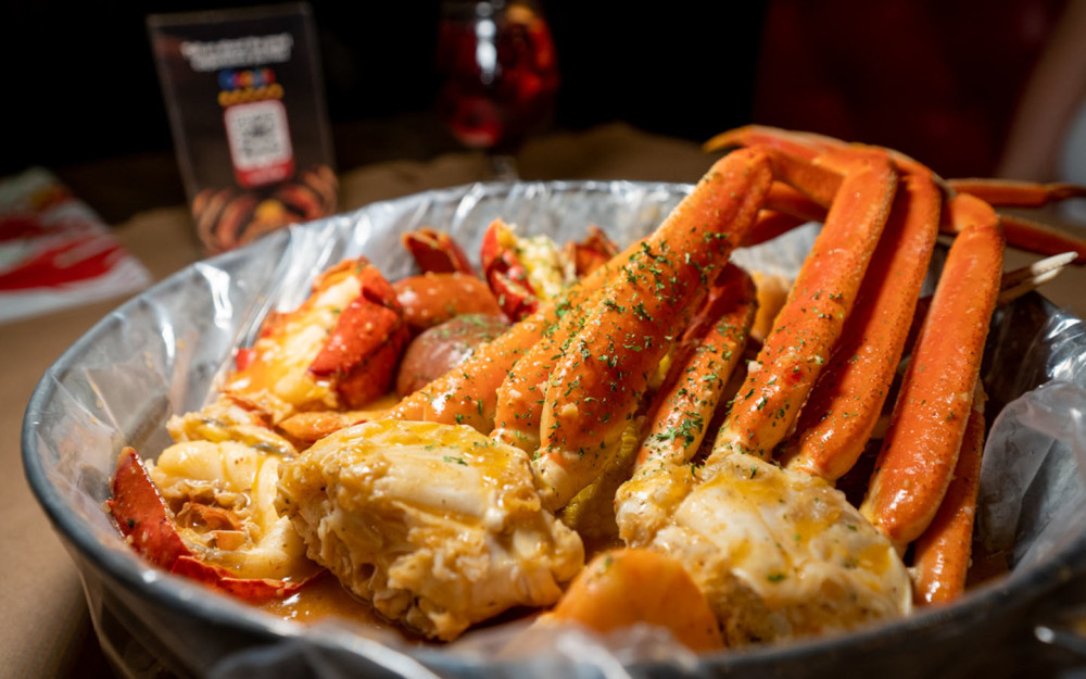 Combo de fruits de mer bouillis avec pattes de crabe des neiges et queue de homard de qualité supérieure.