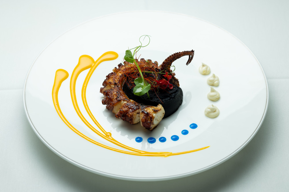 Oktopus mit Tintenfisch-Hummus, Safran und Limetten-Chefsauce.