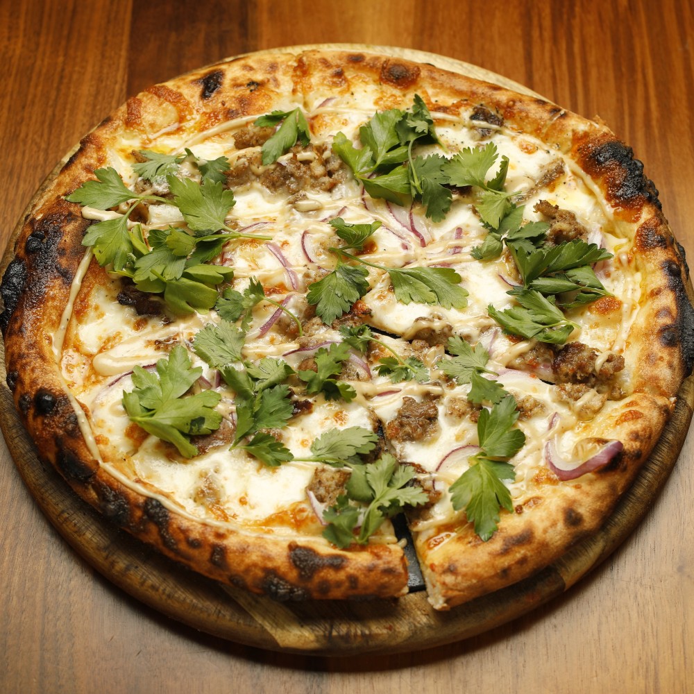 pizza de salchicha de pollo, crema de tahini, mezcla de hierbas