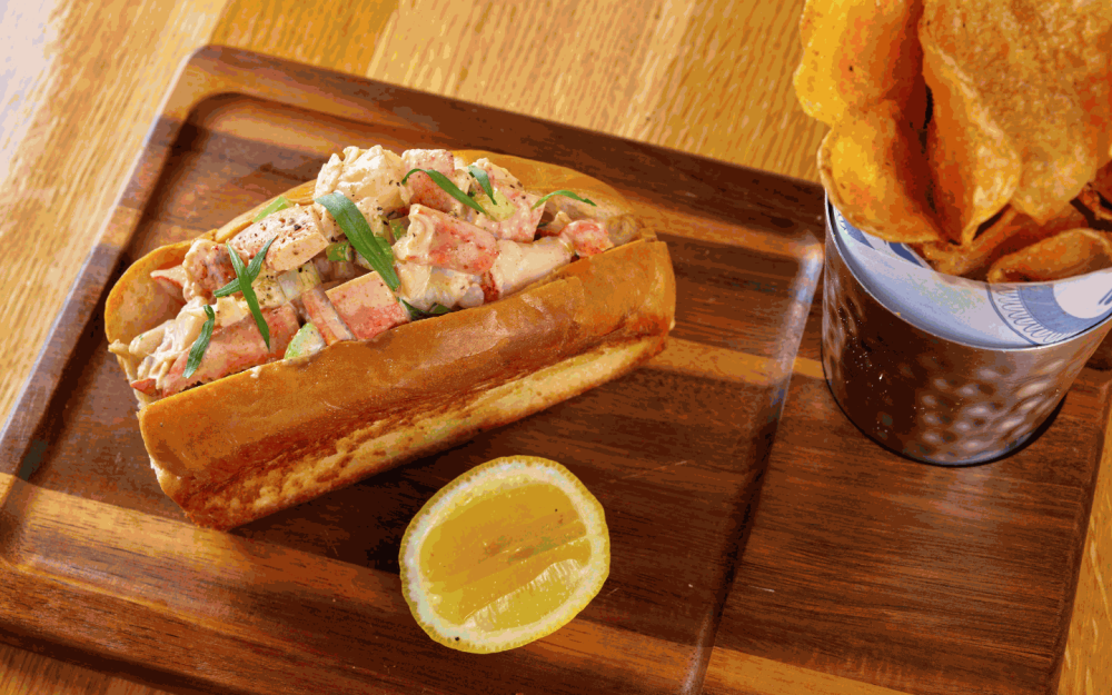 Savor coastal flavors with the New England lobster roll with celery, Cajun mayo, on a soft toasted bun.