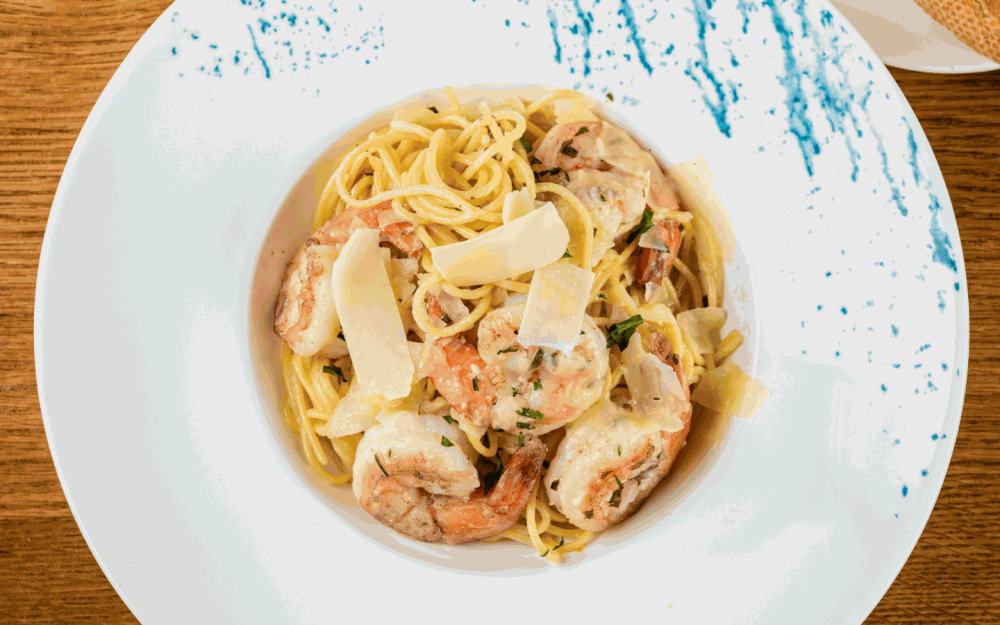 Découvrez le bonheur culinaire avec nos langoustines aux crevettes. Crevettes méditerranéennes, linguines, copeaux de parmesan et beurre citron-ail.