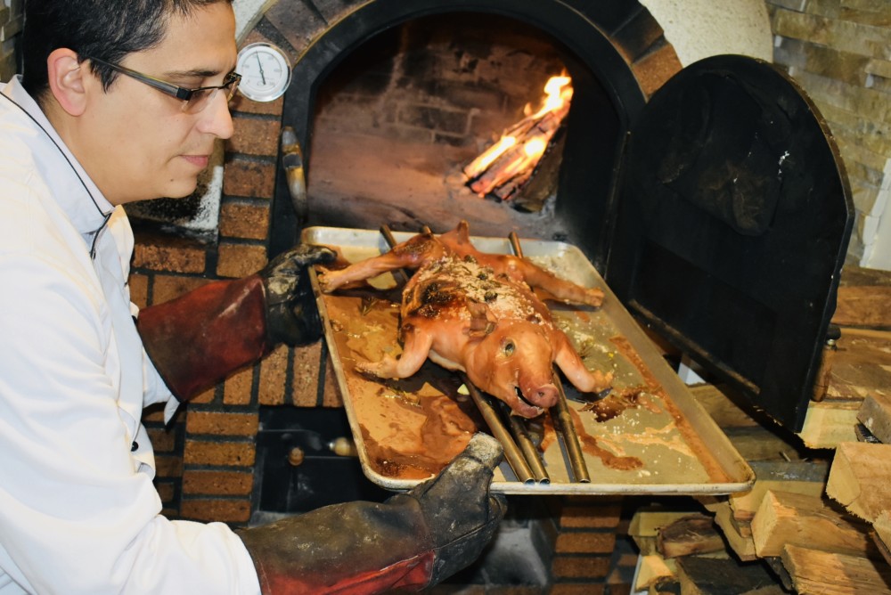 スペインから持ち込んだ伝統的な薪オーブン「コチニージョ・ア・ラ・レーニャ・エスティロ・セゴヴィアーノ」で丸ごとローストした子豚。