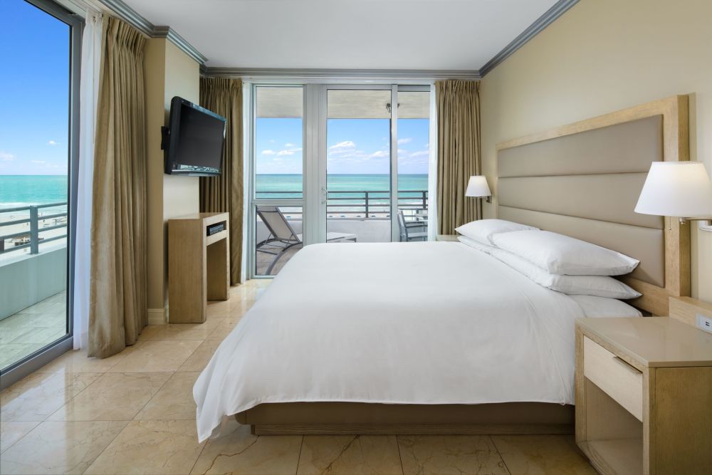 Impresionante suite con vista al mar, terraza privada, dormitorio principal, sala de estar independiente con cocina completa.
