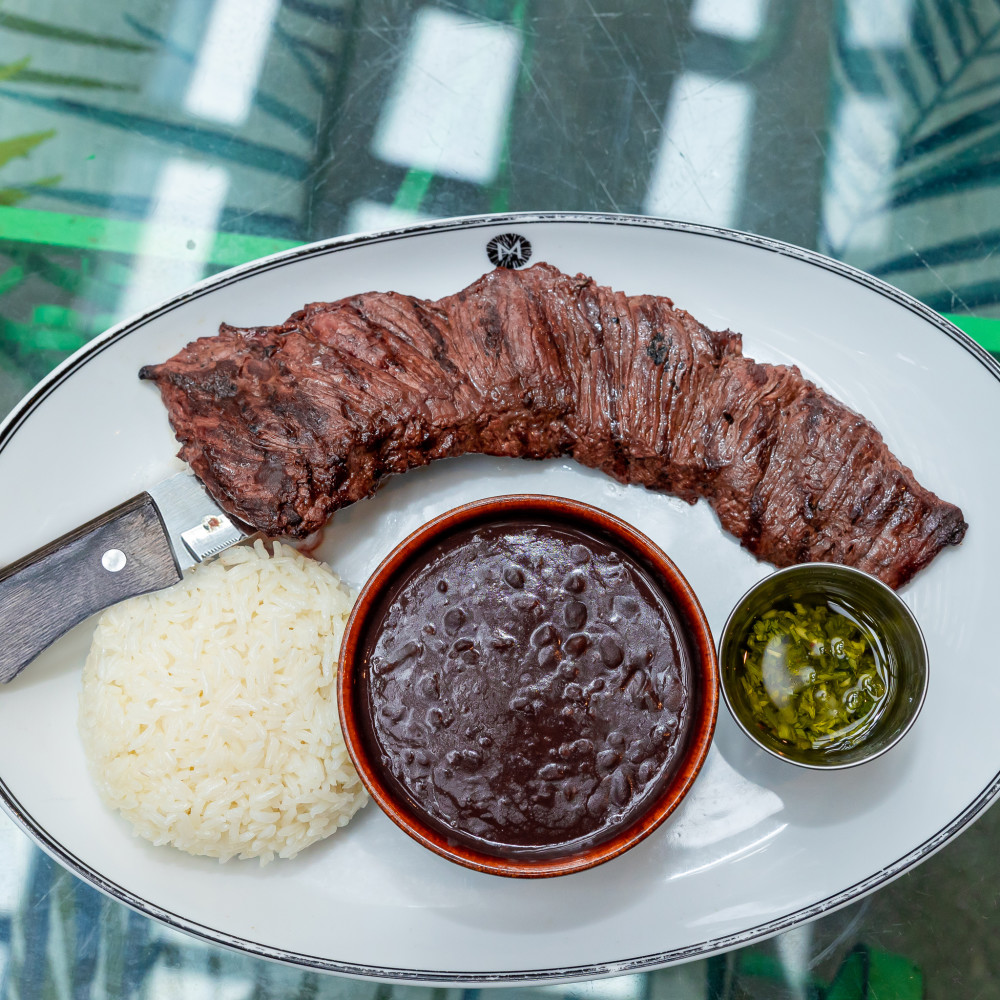 Coal grilled skirt steak served with chimichurri sauce, white rice and black beans