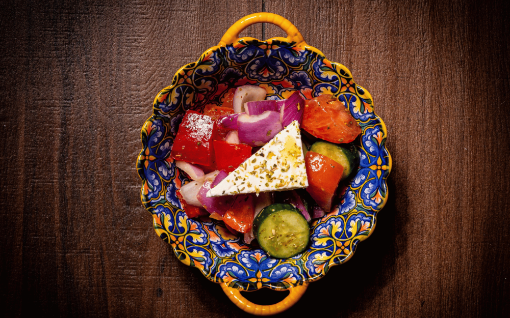 Greek salad with cucumber, tomato, red onion, olives, and red bell pepper, finished with a fresh lemon vinaigrette.