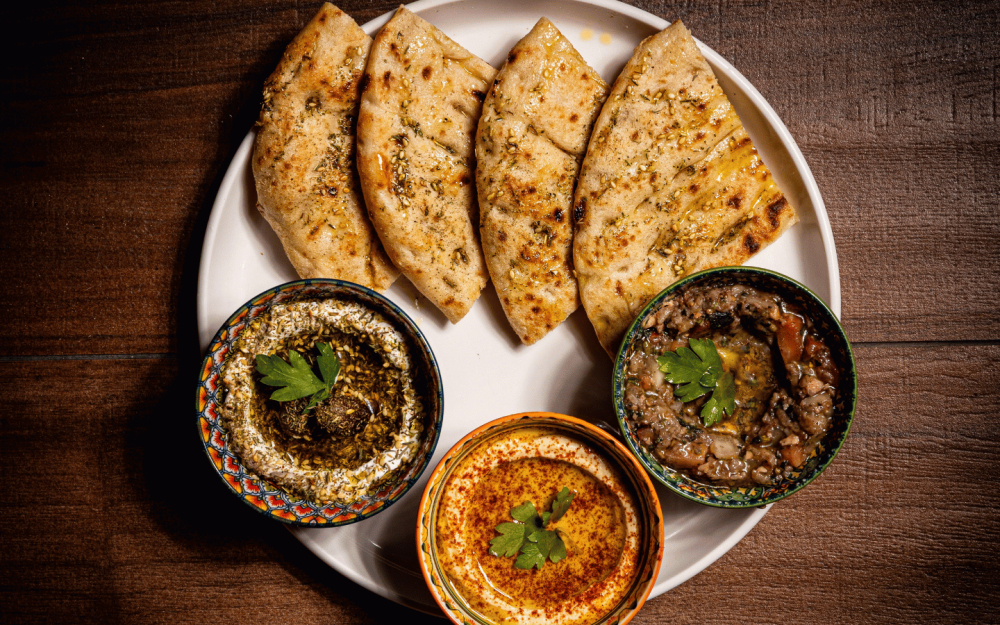 Mediterranean Mezze Trio — Hummus, baba ghanoush, labneh, warm pita bread