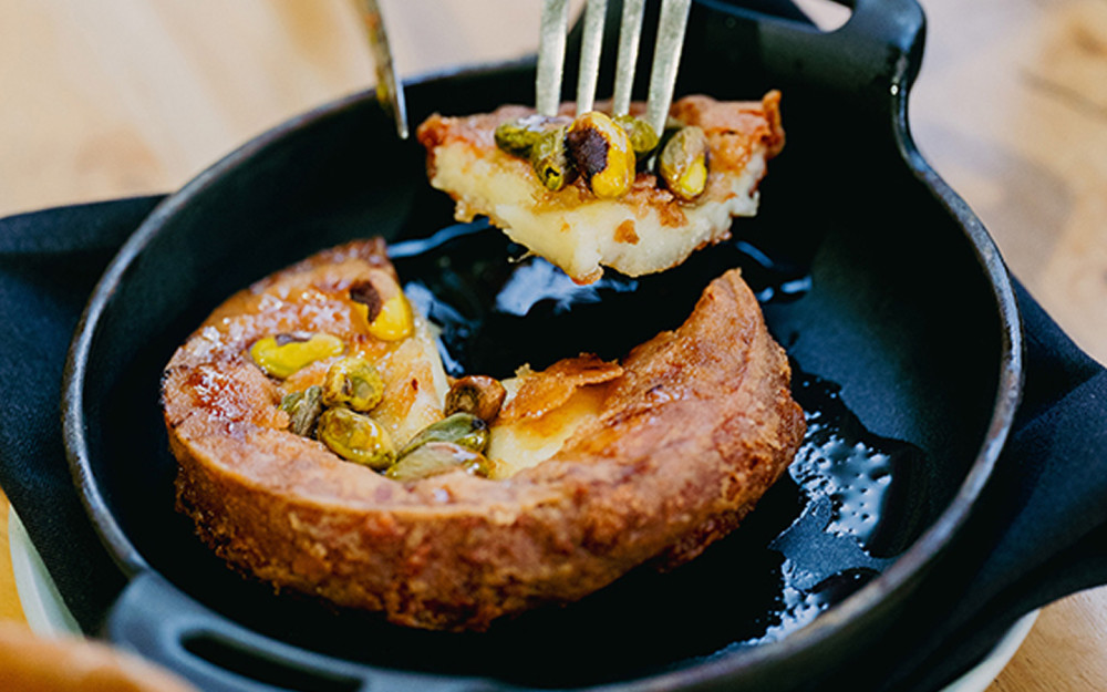 Honey, Saganaki cheese flambeé with , pistachio crumble.