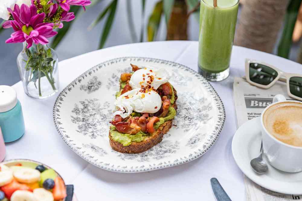 Avocado toast with poached eggs and chili flakes—would you pair it with a bold coffee or keep it cool with a green smoothie? Your call.