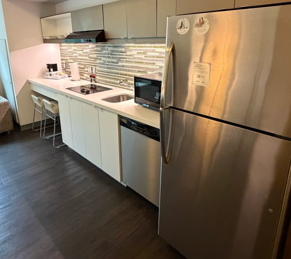 Fully equipped kitchen, features energy-efficiency appliances, full-size refrigerator, dishwasher, stovetop cooktop, microwave, and filtered water tap
