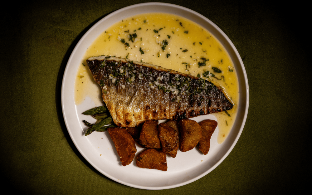 Branzino Mediterraneo — Whole grilled branzino, crispy potatoes, grilled asparagus, lemon butter sauce