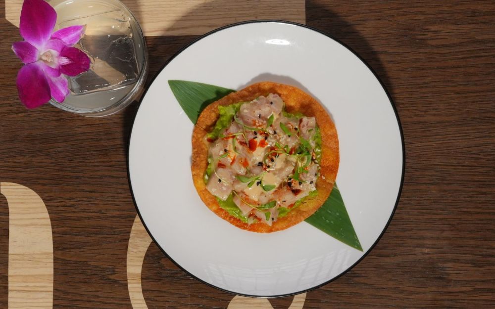 Hamachi, avocado purée, red onion, sesame seeds, chipotle mayo, and micro cilantro on a crispy tortilla.