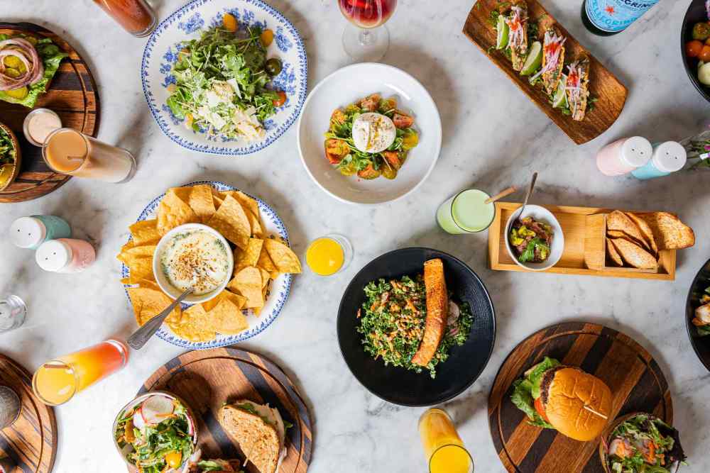 A feast for every craving—tacos, nachos, salads, burgers, and fresh juices all come together at Orange Blossom for the perfect table spread.