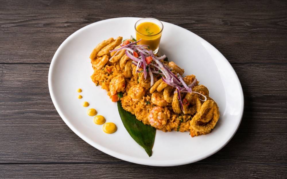 Creamy Peruvian-style rice with shrimp, Parmesan and ají peppers, topped with fried calamari, criolla salsa and E41 Tiger’s Milk