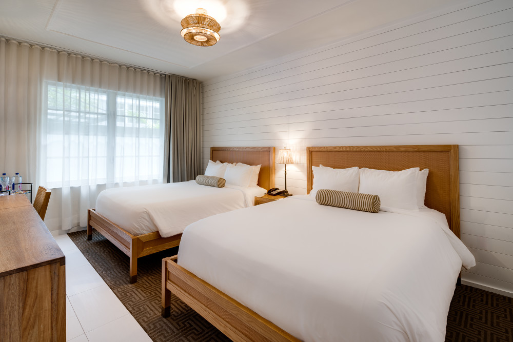 Renovated Double Queen rooms offer two full beds with crisp linens, beachy-chic art, soothing tones, and refined wood for a relaxing stay.