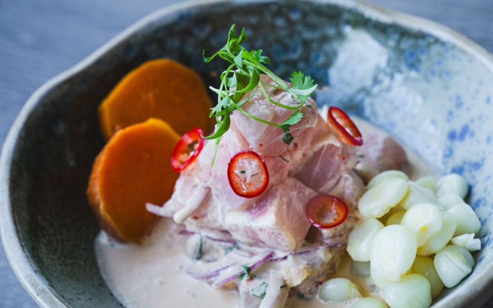 Fresh corvina marinated in lime juice, ají limo, onions and cilantro, served with Peruvian corn and glazed sweet potato