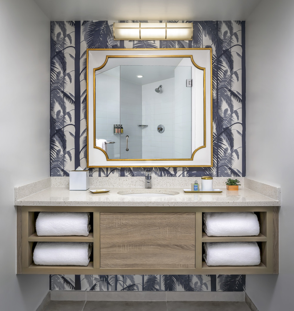 Blue palm trees adorn the bathroom walls.