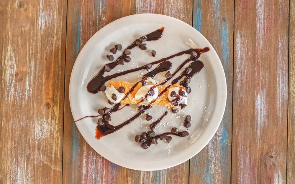 Originating from Sicily, consisting of tube-shaped, fried pastry shells filled with a sweet, creamy filling and topped with chocolate chips and syrup.