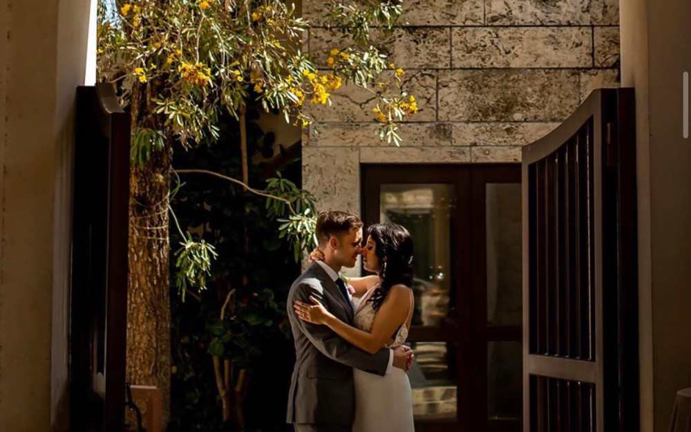 A couple shares a romantic moment in the historic courtyard at the Coral Gables Museum.
