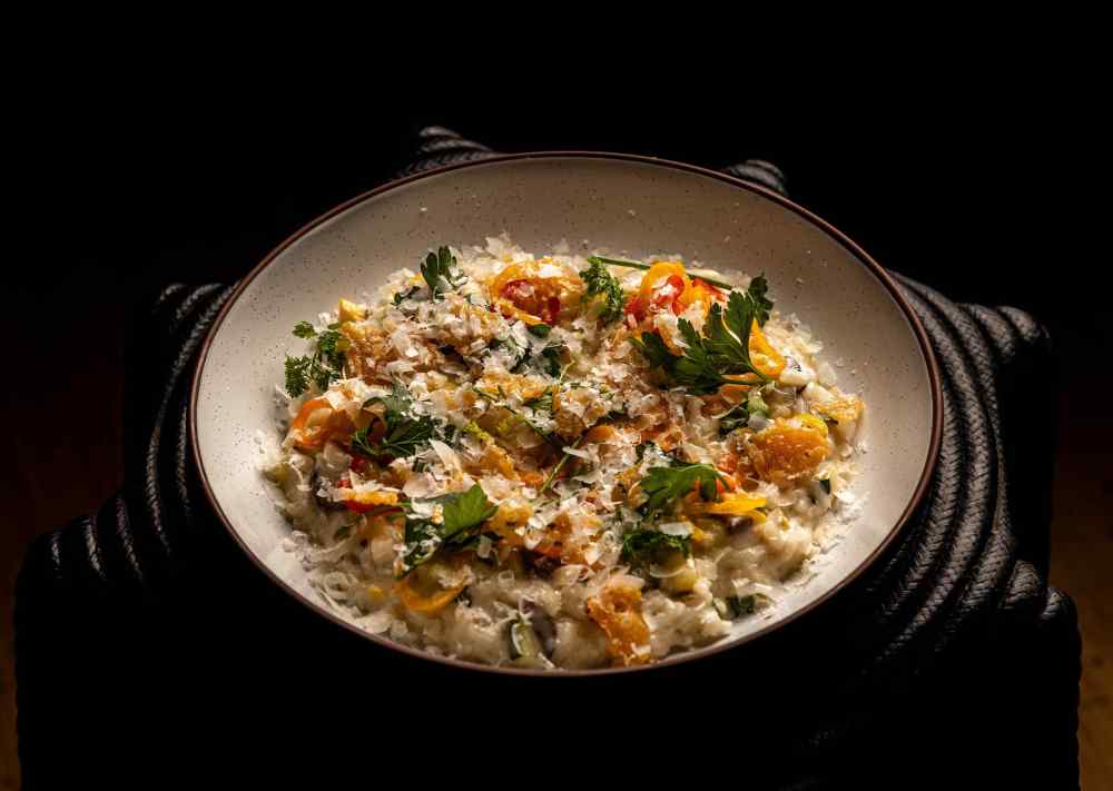Creamy vegetable risotto at The Grove, elevated with seasonal flair, crispy parmesan, and tender herbs. And yes, you can add truffle.