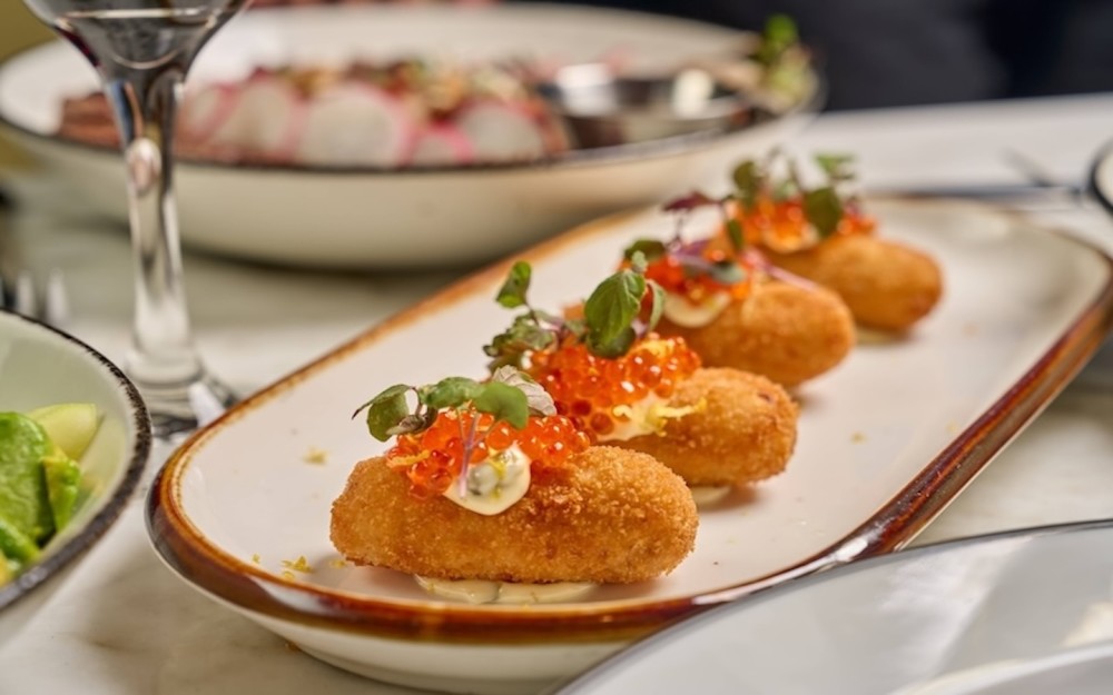 4 croquetes de salmão defumado norueguês, molho bechamel, cream cheese Philadelphia, caviar de salmão e aioli de alcaparras