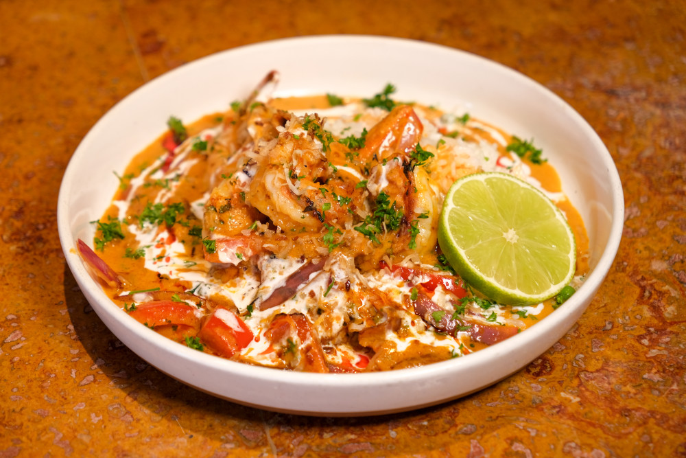 Grilled shrimp with a tomato coconut sauce over a bed of white rice