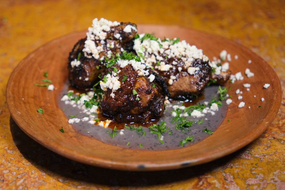 mini pig wings with a chile glaze, black beans pure and queso fresco