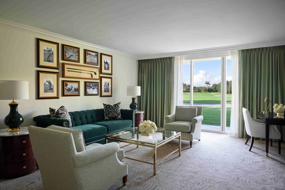 Spacious 1,050 sq. ft. Deluxe One-Bedroom Suite with king bed, separate living area, marble baths, luxury amenities, and resort views.