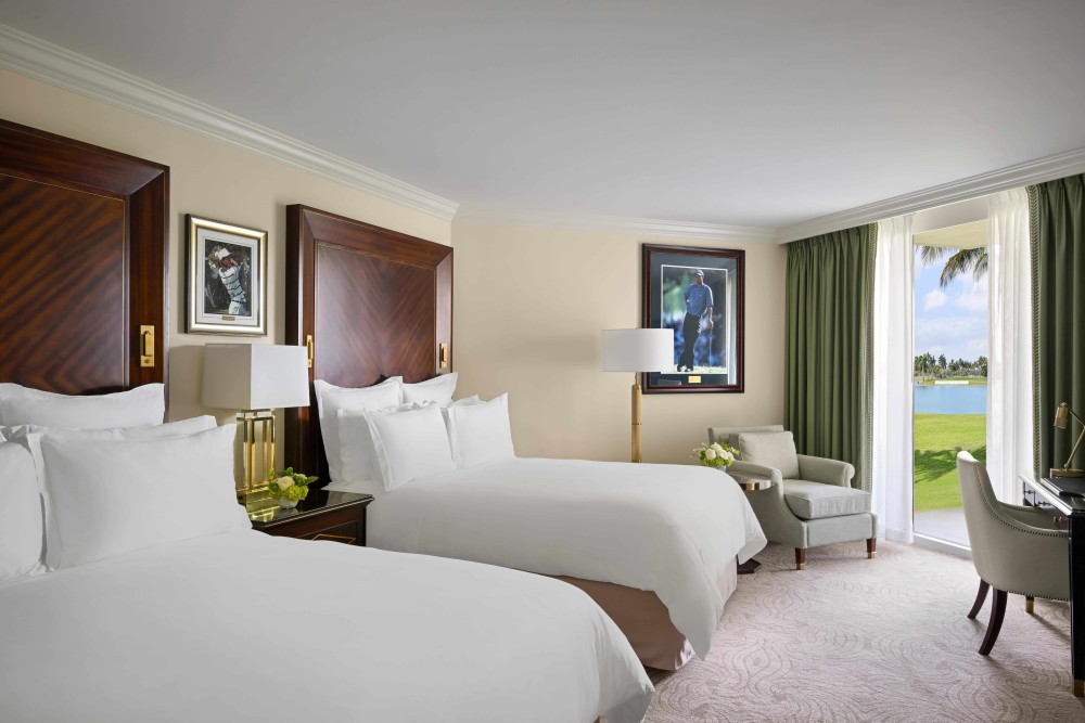 Luxurious Deluxe Double Queen room featuring elegant décor, marble bath, premium amenities, and beautiful resort views. 343–375 sq. ft.