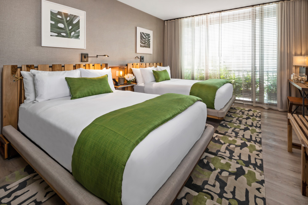 Double Room with Pool View
These redefined spacious guestrooms are located conveniently in the courtyard with direct access to the pool and pool bar. The guest will enjoy a relaxing morning, afternoon or all day stay by the pool relishing with our lounge chairs from the Italian Designer Paola Lenti. Maximum guest of 2 in King size bedding room and 4 guests in the 2 double bed rooms.
Features:
•	Modern guestrooms with “feel at home” interiors.
•	280- sqf to 340 sqf I 26 sqm – 32 sqm.
•	Light wooden floors, natural wood handmade furniture from Patagonia, plush luxurious bedding sheets and pillows, recycled material hangers, wood and leather combined night stands
•	Marble glass-enclosed shower bathrooms with ample rain shower heads
•	King (1) or 2 Double size beds
•	Desk and leather chair
•	Night turndown (requested)
•	Alarm clock