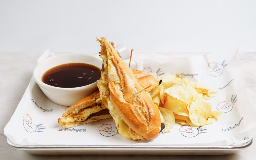 Rosbif, queso suizo y cebollas caramelizadas, salsa para mojar “au jus”.