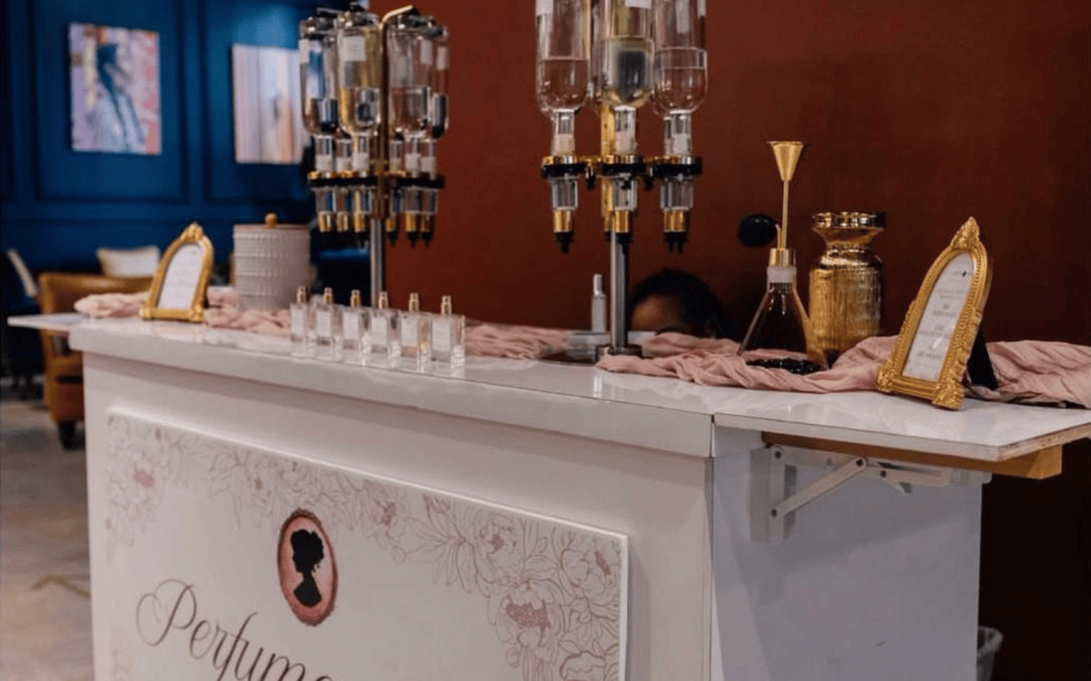 Elegant fragrance bar setup with multiple perfume dispensers and display signage.