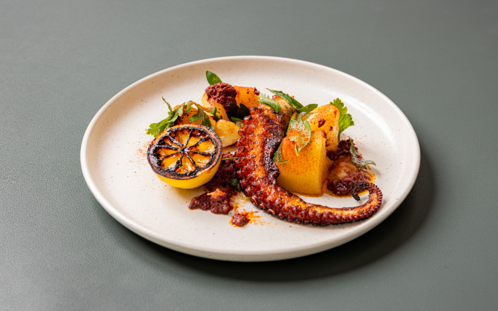 Grilled octopus perfection at The Drexel—served with charred lemon, golden potatoes, and fresh herbs in the heart of Miami Beach.