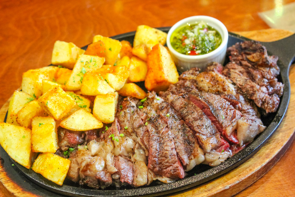 Grilled Skirt Steak: Skirt steak cooked on the grill to your liking; topped with sauteed onion and served with deep-fried diced potatoes.