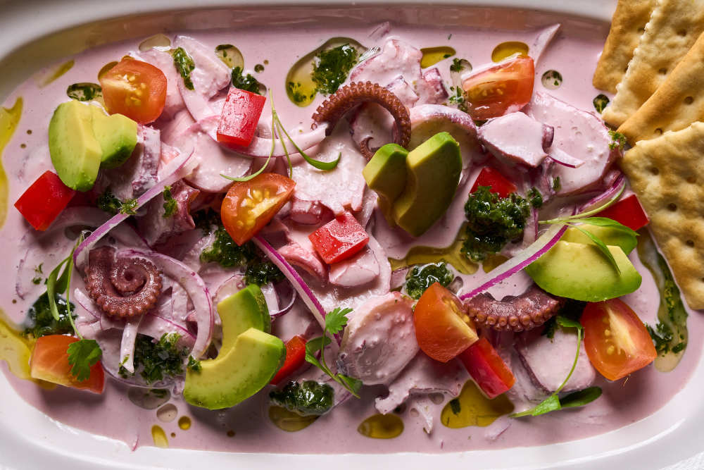 Thinly sliced octopus with avocado in a creamy black olive sauce, served with crisp soda crackers.