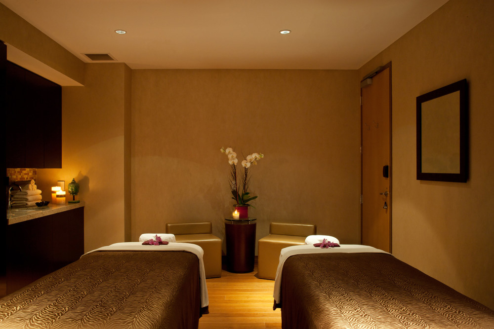 A serene spa suite featuring two massage beds designed for relaxing couples treatments and shared wellness experiences.