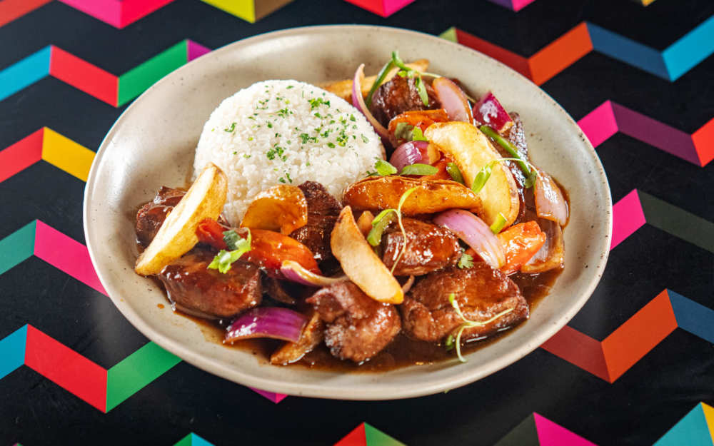 Lomo Saltado: beef tenderloin sauteed with onion, tomato, ají, & potato served with rice