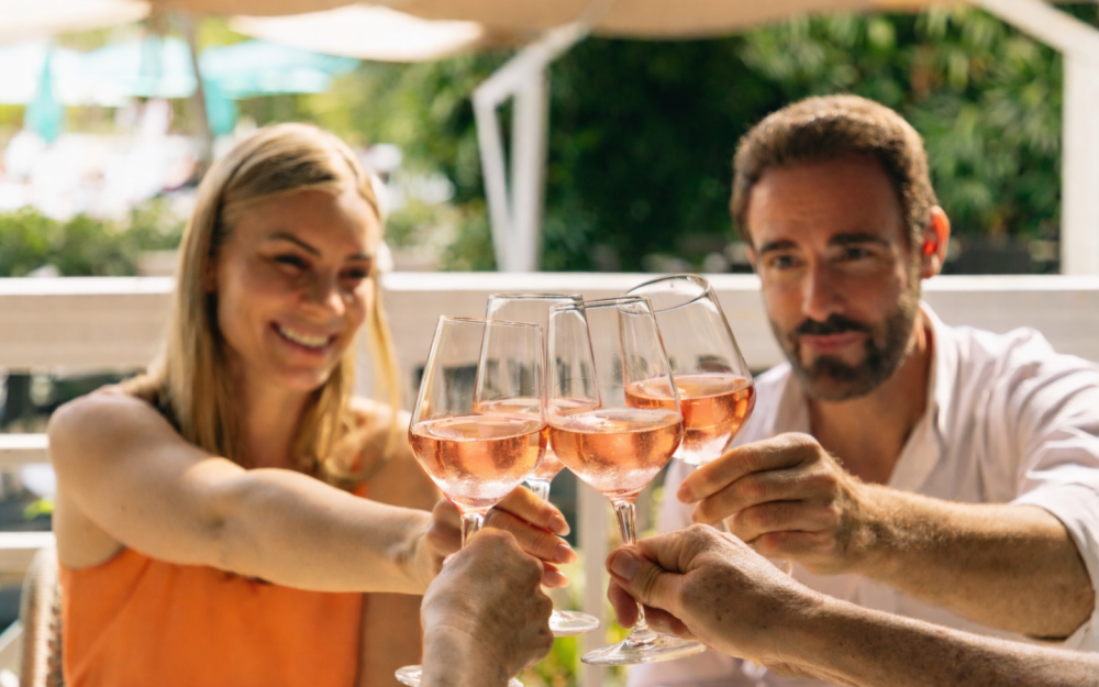 Friends toast with Rosé in Essensia’s tropical lounge terrace, soaking in golden hour vibes and laid-back Miami charm.