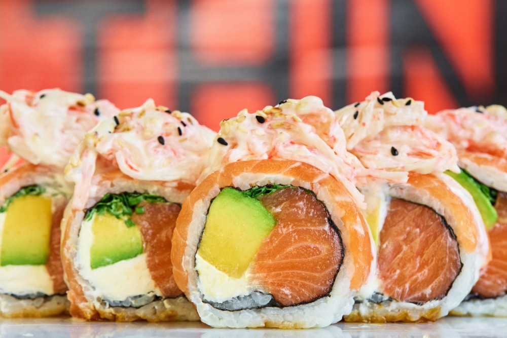 Fresh salmon, avocado, scallions, cream cheese, fresh salmon topping, dynamite mix (shredded kani and mayo), orange and honey sauce.