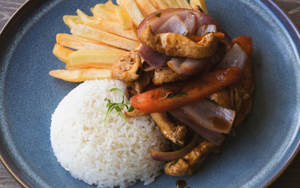 Diced chicken, stir-fried with tomatoes, onions, yellow chili pepper in julienne, sautéed with soy sauce, served with French fries and white rice
