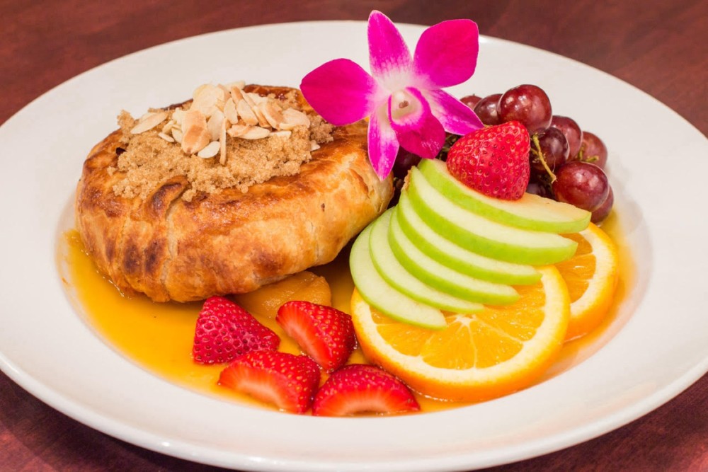 Baked Brie, whole baked Brie wrapped in crispy puff pastry and drizzled with warm apricot glaze. Served with fresh fruit and crackers.