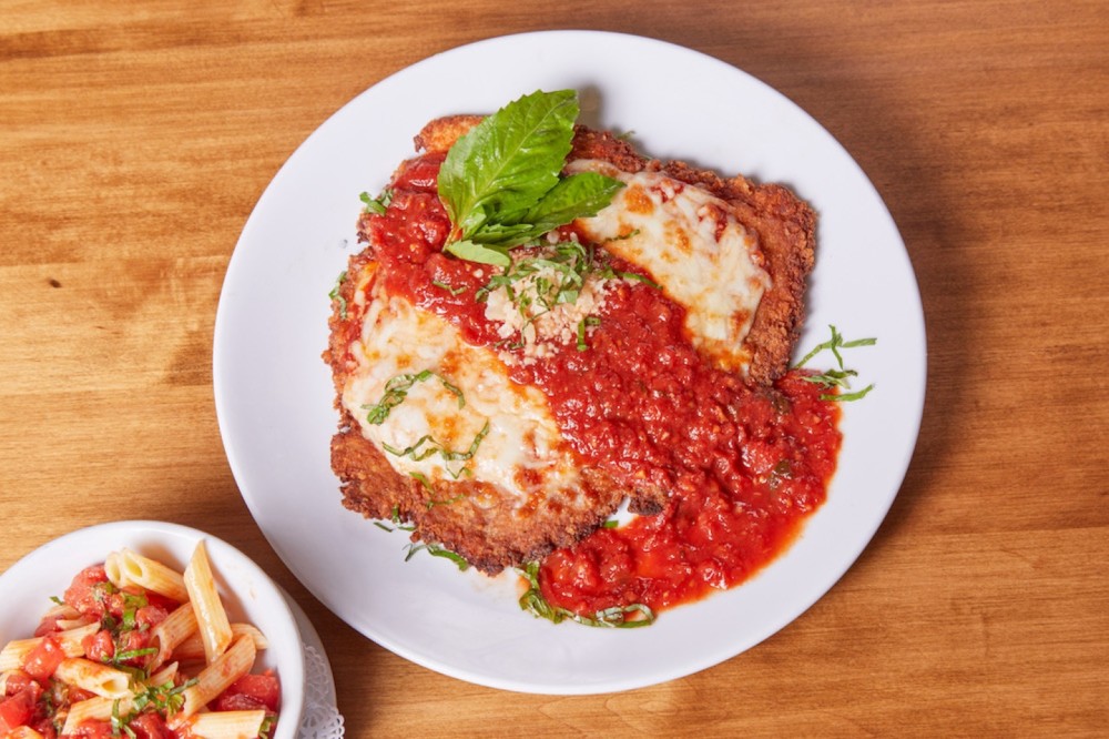 Delicately seasoned and lightly fried chicken breast topped with pomodoro sauce and melted mozzarella cheese, served over penne.