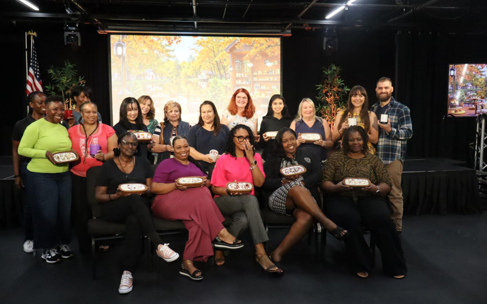 A joyful group proudly shows off their finished creations after a workshop.