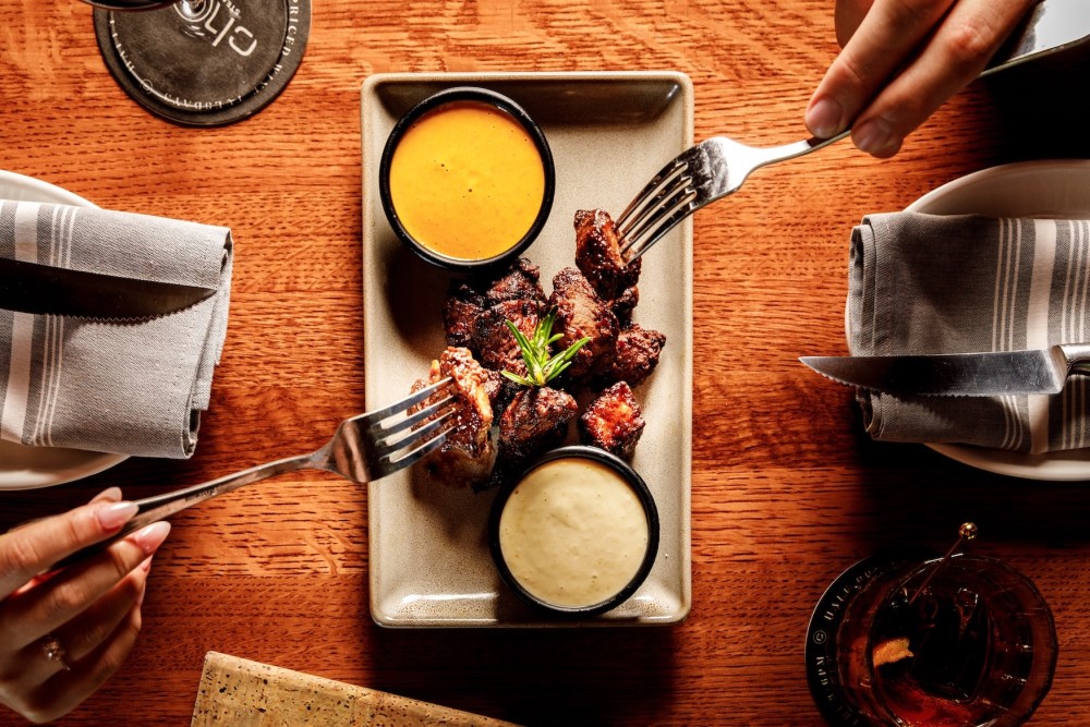 Our signature steak bites are a must-try appetizer in Coconut Grove, served with two house-made sauces and perfect for sharing.